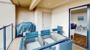 A balcony with wicker furniture, a door, and a view into the living area. - 2BR lakeside condo with shared pools and hot tub (Chelan)