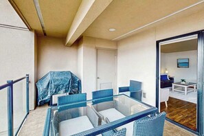 A balcony with wicker furniture, a door, and a view into the living area. - 2BR lakeside condo with shared pools and hot tub (Chelan)