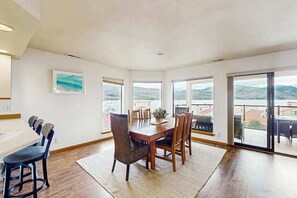 A dining area with a table and chairs, large windows, and a view of the outdoors. - 2BR lakeside condo with shared pools and hot tub (Chelan)