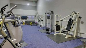A gym with exercise equipment, including a treadmill, weight machines, and a TV screen. - 2BR lakeside condo with shared pools and hot tub (Chelan)