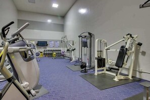A gym with exercise equipment, including a treadmill, weight machines, and a TV screen. - 2BR lakeside condo with shared pools and hot tub (Chelan)