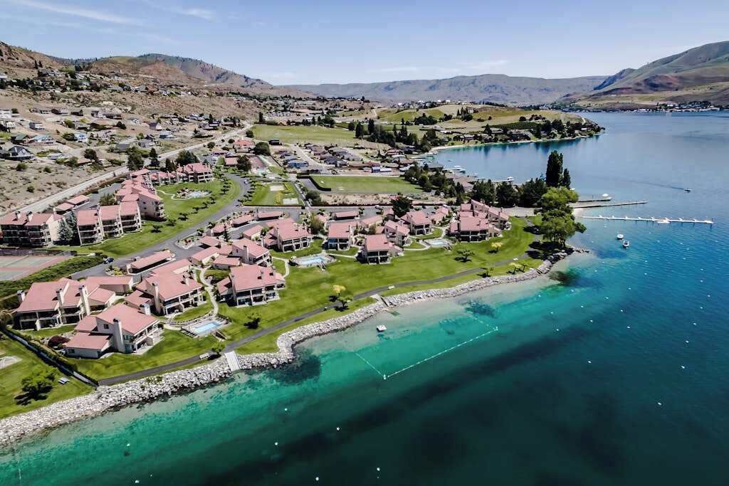 A coastal resort with multiple buildings, a marina, and clear waters.