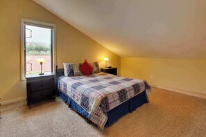 A bedroom with a bed, a nightstand, a lamp, and a window. - Lovely 2BR Lakefront - Balcony - Pool (Chelan)