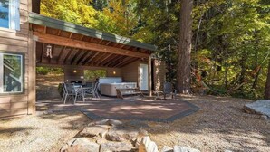 Eine Hütte mit überdachter Terrasse, Grill und Sitzgelegenheit.