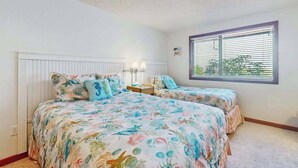 A bedroom with two beds, a window with blinds, a nightstand, and a lamp. - Charming 2BR Lakefront - Patio - Pool (Chelan)