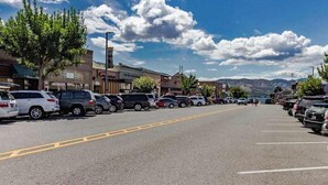 A parking lot with multiple cars, buildings, and a clear sky. - Charming 2BR Lakefront - Patio - Pool (Chelan)