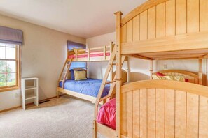 A room with bunk beds, a window with blinds, and a white shelf unit. - 3BR Lakeview - Pool - Dock - Deck (Manson)