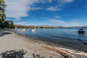 A lakeside view with boats, a sandy beach, and a clear sky. - 3BR Lakeview - Pool - Dock - Deck (Manson)