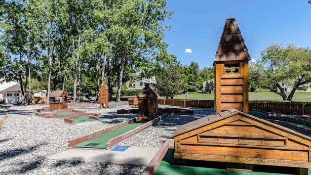 Ein Minigolfplatz mit Holzelementen und einer grünen Spielbahn.