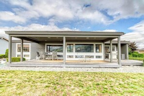 Ein überdachter Patio-Bereich mit Sitzgelegenheiten und Blick auf die umliegende Landschaft.