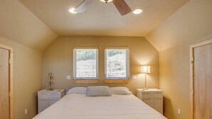 A bedroom with a large bed, two windows, a ceiling fan, bedside lamps, and a nightstand. - Lovely 3BR Lakeview - Deck - Ping Pong - W&D (Manson)
