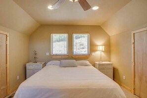 A bedroom with a large bed, two windows, a ceiling fan, bedside lamps, and a nightstand. - Lovely 3BR Lakeview - Deck - Ping Pong - W&D (Manson)