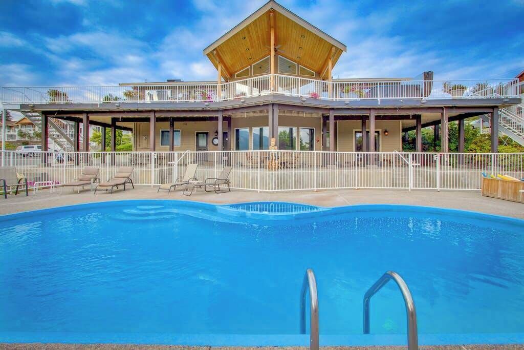 Ein zweistöckiges Gebäude mit einem Pool im Vordergrund.