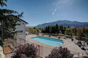 A residential swimming pool with a view of mountains in the background. - Downtown 2BR - Patio - Pool - Washer/Dryer (Chelan)