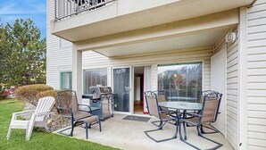 A covered patio with a grill and outdoor furniture. - Downtown 2BR - Patio - Pool - Washer/Dryer (Chelan)