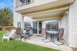 A covered patio with a grill and outdoor furniture. - Downtown 2BR - Patio - Pool - Washer/Dryer (Chelan)