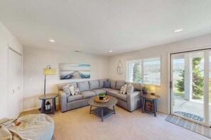 A modern living room with a sectional sofa, a coffee table, and a side table with a lamp. - 4BR Lakeview - Pool - Fireplace - Deck (Manson)
