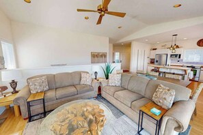 A spacious living room with a large sectional sofa, a coffee table, and a ceiling fan. - 4BR Lakeview - Pool - Fireplace - Deck (Manson)