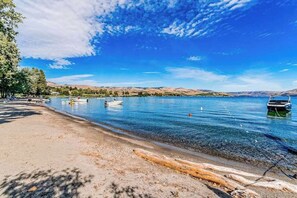 A lakeside view with boats, a sandy beach, and a clear sky. - 4BR Lakeview - Pool - Fireplace - Deck (Manson)