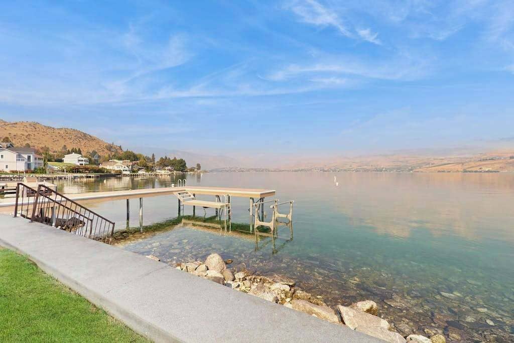 A clear lake with a dock and a staircase leading to a pier.