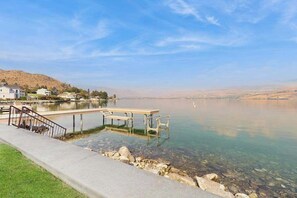 Un lago transparente con un muelle y una escalera que lleva a un espigón.