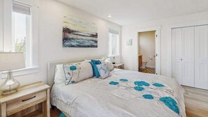 A bedroom with a bed, bedside tables, a painting, and a wardrobe. - Gorgeous 3BR Lakefront - Dock - WoodStove (Chelan)