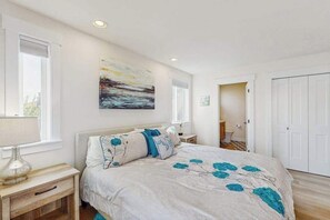 Ein Schlafzimmer mit Bett, Nachttischen, einem Gemälde und einem Kleiderschrank.