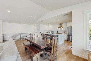 A modern kitchen with a central island, wooden dining table, and chairs. - Gorgeous 3BR Lakefront - Dock - WoodStove (Chelan)