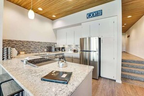 A modern kitchen with a marble countertop, stainless steel appliances, and a sign that reads 'GUMP THE LAKE'. - Comfy 1BR Lakefront - Patio - Pool - (Chelan)