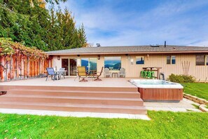 A house with a patio, outdoor seating, a hot tub, and a view of the mountains. - Peaceful 3BR Lakeview - Hot Tub - Fireplace (Manson)