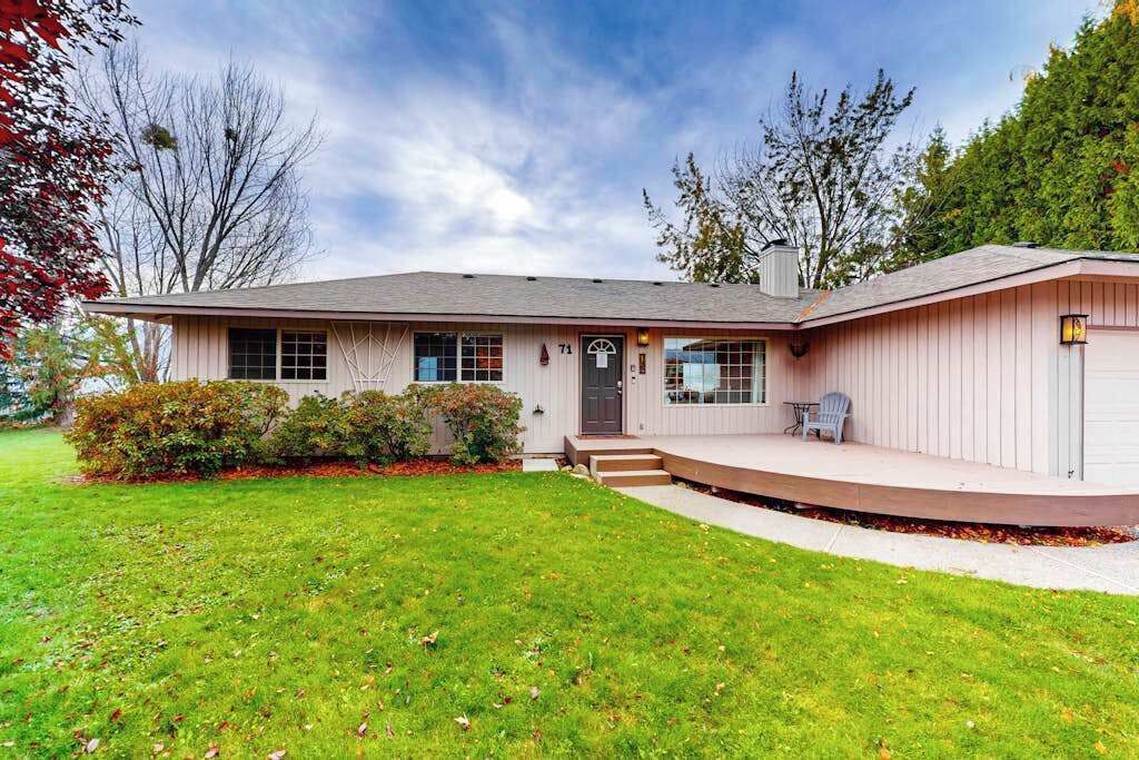 A single-story house with a front porch, a garage, and a well-maintained lawn.