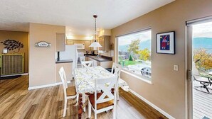 A modern kitchen with a dining area, large windows, and a view of the outdoors. - Peaceful 3BR Lakeview - Hot Tub - Fireplace (Manson)