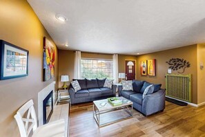 A living room with two sofas, a coffee table, a fireplace, and artwork on the walls. - Peaceful 3BR Lakeview - Hot Tub - Fireplace (Manson)