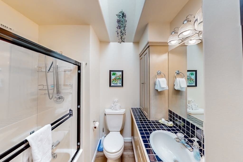 Une salle de bain compacte comprenant une douche à parois de verre, des toilettes, un lavabo et une baignoire.