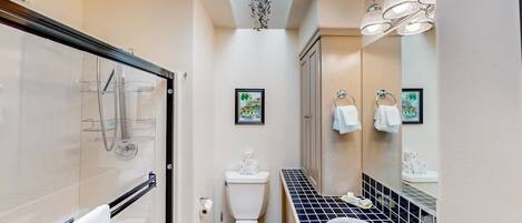 Une salle de bain compacte comprenant une douche à parois de verre, des toilettes, un lavabo et une baignoire.