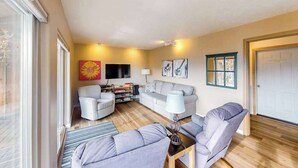 A living room with a sofa, armchairs, a TV, and artwork on the walls. - Peaceful 3BR Lakeview - Hot Tub - Fireplace (Manson)