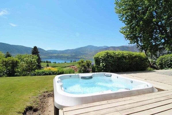 A hot tub on a wooden deck with a scenic view of mountains and a lake. - Peaceful 3BR Lakeview - Hot Tub - Fireplace (Manson)