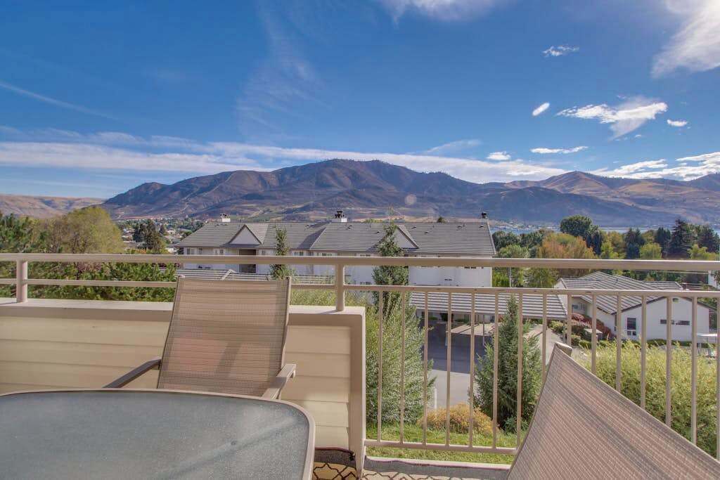 Un balcon avec vue sur les montagnes et les immeubles d’habitation.