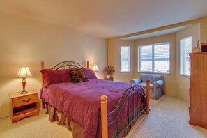 A bedroom with a bed, bedside tables, a dresser, and a window with blinds. - Welcoming 2BR Lakeview - Balcony - Pool (Chelan)