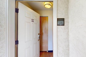 Ein Hotelzimmer-Eingang mit geschlossener Tür, einem Rauchverbot-Schild und einem Zimmerschild mit der Nummer 506.