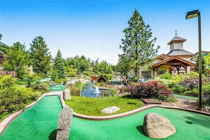 A miniature golf course with a putting green, a water hazard, and a small building structure. - 2BR 1st-Floor - Icicle Village Resort Condo (Leavenworth)