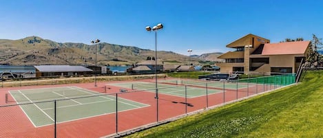 Un campo da tennis con un edificio sullo sfondo.