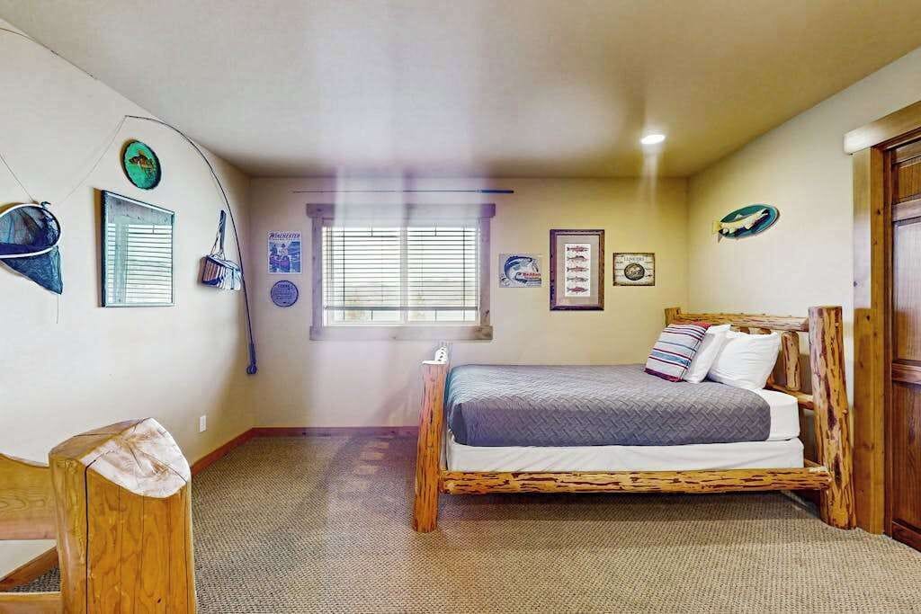 A bedroom with a wooden bed, a window with blinds, and wall decorations.