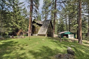 Una cabana amb teulada inclinada, envoltada per un bosc.
