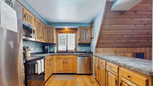 Una cocina con gabinetes de madera, un refrigerador de acero inoxidable y un lavavajillas.