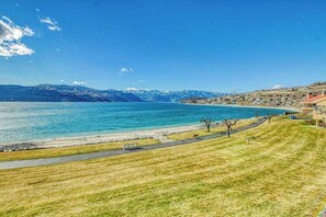 Eine Küstenlandschaft mit freiem Blick auf das Meer und ferne Berge.