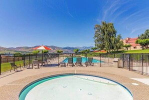 A swimming pool with a view of mountains, surrounded by a fence, and outdoor seating. - Huge 1BR Lakefront 2nd-Floor - Balcony - Pool (Chelan)