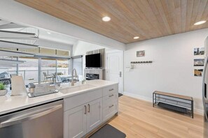 Een moderne keuken met een groot eiland, inbouwapparatuur en uitzicht op de omgeving.