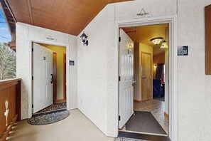 A hotel entrance with two doors, a wooden bench, and a tiled floor. - 2 BR condos located in the Icicle Resort (Leavenworth)