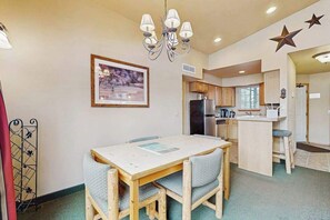 A compact living space with a dining area, kitchenette, and a large window. - 2 BR condos located in the Icicle Resort (Leavenworth)